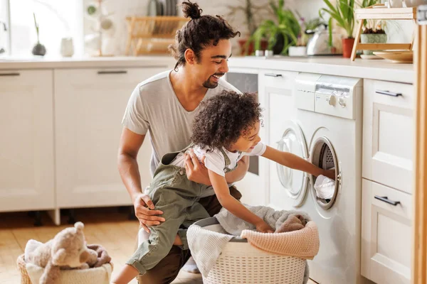 Fröhlicher Schwarzer Junge Hilft Vater Beim Wäschewaschen Neben Waschmaschine Flugküche — Stockfoto