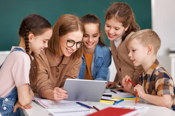 Happy Female Tutor Optimistic Children Smiling Watching Video Tablet While — Stock Photo, Image