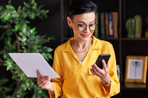 Mature Female Manager Stylish Yellow Blouse Glasses Reading Data Paper — Stock Photo, Image