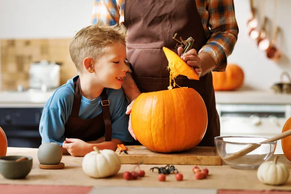 Lindo Niño Feliz Ayudando Padre Tallar Calabaza Halloween Mientras Está —  Fotos de Stock