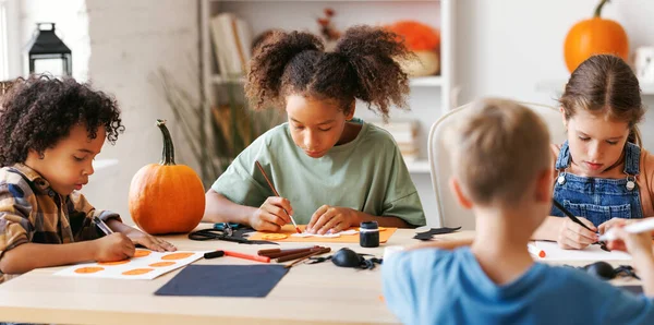 ハロウィーンの家の装飾を一緒に作る子供の多国籍グループ 子供はカボチャを絵画し 紙の切断を作る — ストック写真