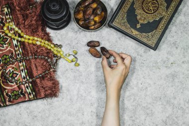 Kuran 'ın Arapça anlamı olan fener ve kutsal Kur' an, Kuran ile namaz kılan paspas, tespih çeken müslüman ve elinde meyve tutan kadın.