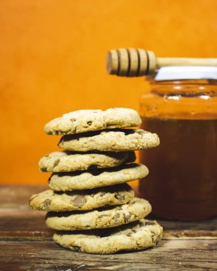 Tahta masada bal kavanozlu ev yapımı çikolatalı kurabiyeler.