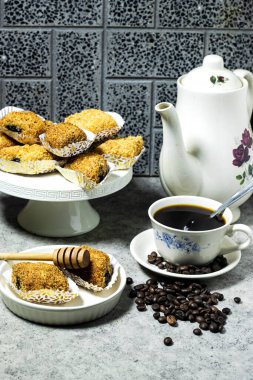 Kızarmış Makrout veya Makroud - Cezayir irini irmiği, hurma ve bal tatlısı, İslamiyet için geleneksel Kuzey Afrika tatlı yiyeceği bir fincan kahve ve kızarmış tahıl