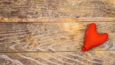Sevgililer günü için ahşap masada kırmızı renkli şişme bir kalp.