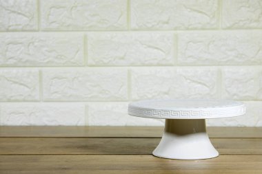 empty white cake stand on wooden table 