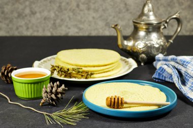 Arapçada Baghrir olarak adlandırılan Fas ya da Cezayir krepleri. Çaydanlık, kuru nane ve kozalaklı bal pekmezli.