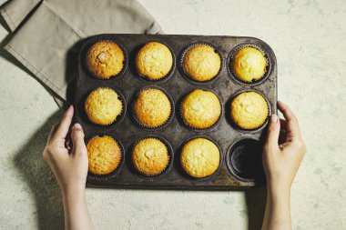 hands holding a Pan Vanilla Caramel Nuts Muffins In Paper Cups