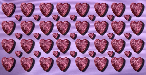 purple glitter hearts on purple background. Heart of glitter grains glitter makeup. background, abstract