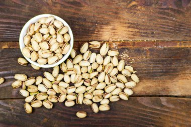 Pistachios in bowl on wooden table