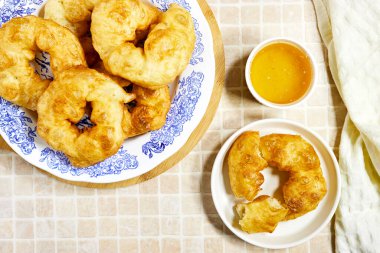 traditional Algerian fried baked donuts or pancake named Sfenj and honey bowl