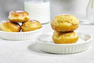 Ev yapımı Cezayir Donutu kayısı reçeli ve pudralanmış şeker, süt ve kamış vazosu.