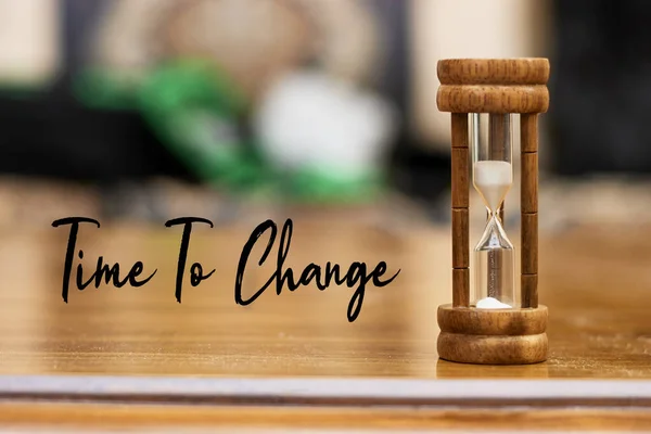 Time to change concept with hourglass on wood table as time passing concept. Life time passing. Meaning of life