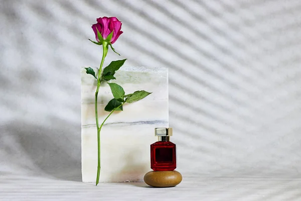 Mermer Kürsü Pembe Gülün Yanında Kırmızı Parfümlü Taş Güzellik Ürün — Stok fotoğraf