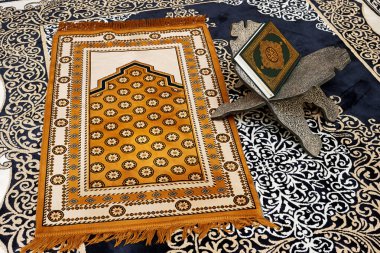 Arapça kaligrafi Kuran 'ı olan bir müslüman kitabının çevirisi: Dünyanın dört bir yanındaki Müslümanların camide namaz kılıfları olan asil kitabı.