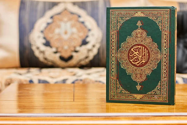 a muslim book with Arabic calligraphy Quran - translation : the noble book    of Muslims around the world on wood table
