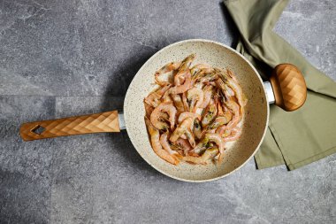 Tavada kızarmış karides, deniz ürünleri ve Akdeniz mutfağı konseptiyle yemek hazırlama.