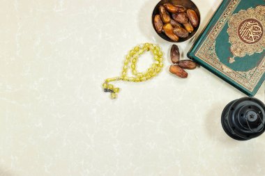Bayram konsepti. Arapça kaligrafi Kuran ile fener ve müslüman kitabı - çeviri: dünyanın dört bir yanındaki Müslümanların asil kitabı ve meyveler, tespih taşları