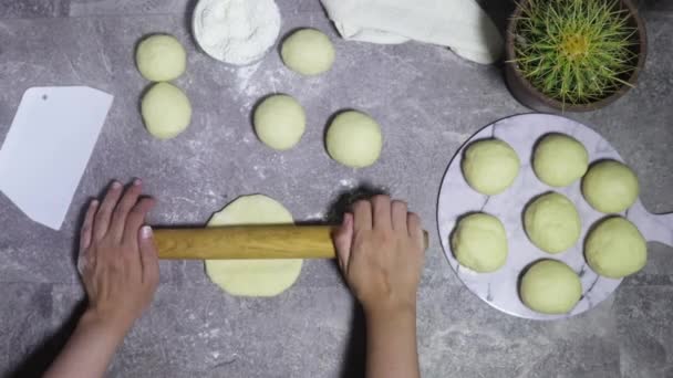 女人们用手在大理石磨擦表面上用滚动销把面团滚出来 关闭烘焙或厨师准备新鲜面团与滚动销在厨房桌子上 — 图库视频影像