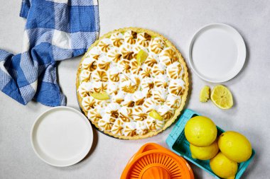 Geleneksel Fransız limonlu tart ve gri arka planda portakal suyu.