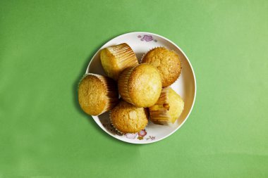 Vanilyalı Karamelli Cevizli Kekler Yeşil arka planda, kağıt bardaklarda