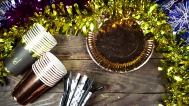 Doğum günü ya da Noel, yeni yıl partisi konsepti, kartla kutlanan kağıt tabak metin ve tek kullanımlık bardak, pipet ve renkli farklı cips ve şekerlerle ahşap masa.