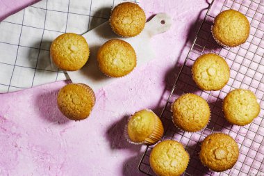 Kağıt bardaklarda vanilyalı karamelli fındıklı çörekler Pembe grunge arka planda ızgaralar