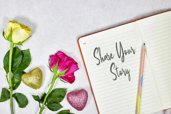 share your story concept om notebook with roses flowers and hearts glitters