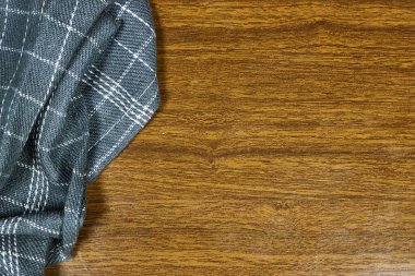 Gri masa örtüsü ve mutfak malzemeleriyle kaplı kahverengi ahşap masa. Yukarıdan bak. Ürün montajı için boş masa örtüsü. Metnin için boş yer