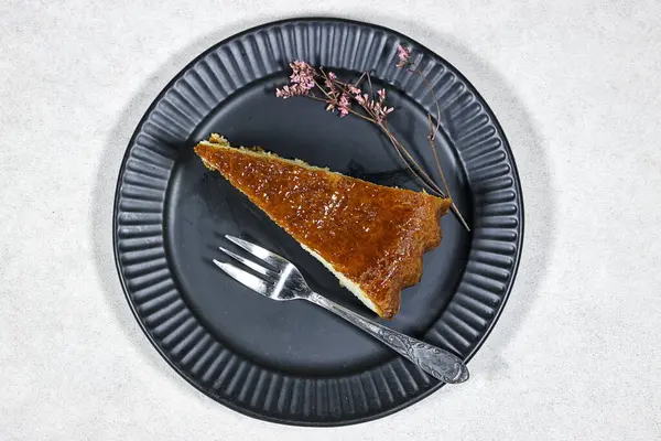 Ev yapımı tatlı romlu baba kayısı reçeli ve jigolo çiçeğiyle süslenmiş.