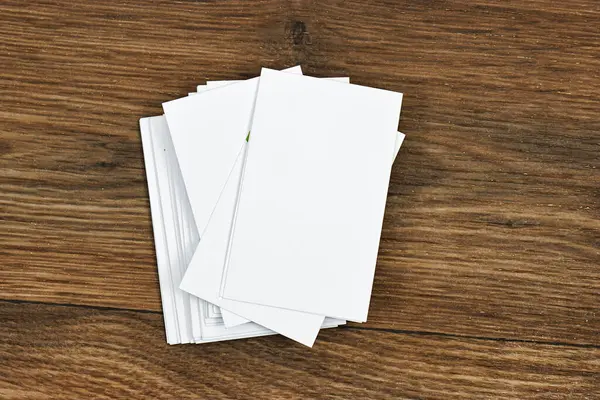 Kurumsal kırtasiye seti ahşap masa üzerinde beyaz desenli kağıt arka plan modelleme