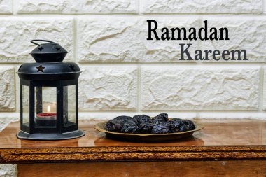 Kutsal Ramazan ayı kavramı, mumlu klasik fener ve ahşap masada meyveler.
