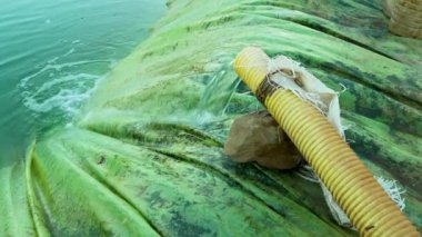 Tarımda sulama için plastik su tutma havzası. Su borusundan akan su dairesel beton bir havzaya akar.