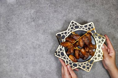 Mutlu ramazanlar ya da bayramlar, Deglet Nour Cezayir yıldız tabağıyla tarihleniyor, eller tek parça tutuyor.