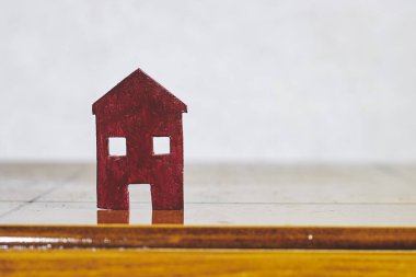 Tahta masadaki küçük ahşap ev modeli. Mülk almayı planlıyorlar. En iyi konsepti seç.