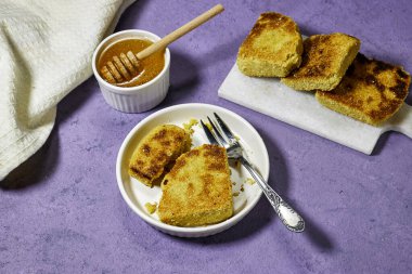 Harcha ya da bayan irmikli Cezayir krepleri kesim tahtasının üstündeki renkli bir tabakta. Ballı geleneksel Cezayir kahvaltı ekmeği