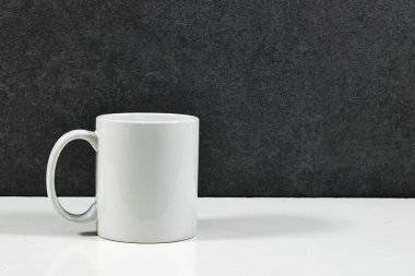 Beyaz kahve fincanı, beyaz porselen bardak beyaz ahşap masada makara yap.