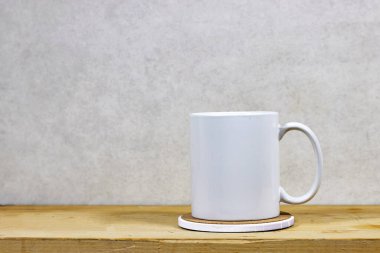 Beyaz kahve fincanı, beyaz porselen bardak beyaz ahşap masada makara yap.