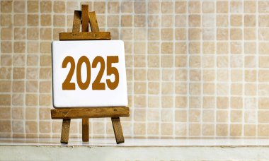 Ahşap sehpalar 2025 yılını simgeleyen 2025 rakamlarını beyaz tahtalarda sergiliyor.