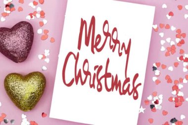 İçinde pembe zarf ve kalp konfetisi olan mutlu noel kartları, tatil konsepti.