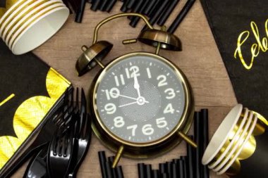 Doğum günü partisi, içinde kutlama mesajı, tek kullanımlık bardak, çatal, pipet ve saat 12 'yi gösteren çalar saat olan kağıt peçete. zaman tatili konsepti