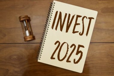 Finansal planlama 2025 konsepti, ahşap masa üzerinde kum saati ile 2025 defter yatırım