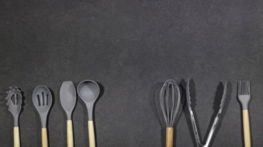 Gri grunge arka planda izole edilmiş ahşap saplı silikon pişirme aletleri. Mutfak araç setleri