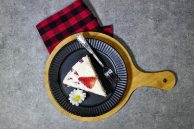 Çilekli kek ya da Fransızcada Fraisier grunge gri arka planda siyah tabakta