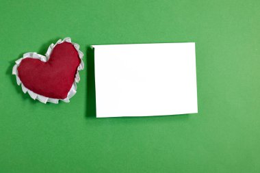 Düğün davetiyesi modeli, pembe arka planda kırmızı kalp oyuncağı. Boş kart maketi