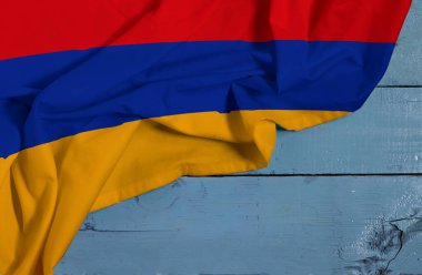 Mavi ahşap arka planda Ermenistan 'ın Saten kumaş desenli bayrağı sallanıyor