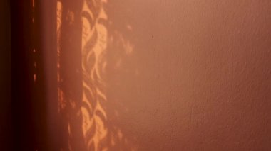 Dokulu Pencere Gölgeleri Turuncu Boyalı Duvar Yüzeyinde Sanatsal Desenler Yapıyor