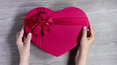 Kapalı eller tatil için kırmızı hediye kutusunu açıyor.