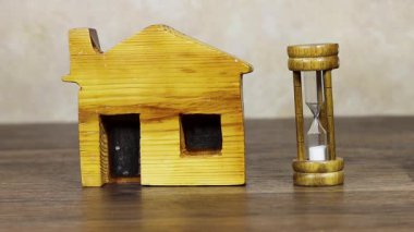 Mini ev ve kum saati mülkiyet zamanı kavramını betimliyor
