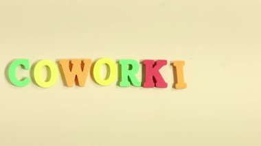 Renkli alfabelerle eşzamanlı çalışan bir metin oluşturan el.